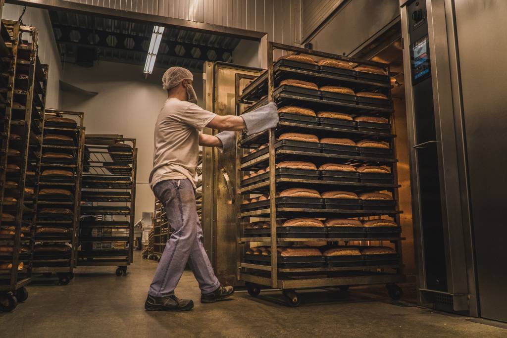 Vooges - De bakker rijdt de vers gebakken broden uit de oven Vooges - De bakker rijdt de vers gebakken broden uit de oven